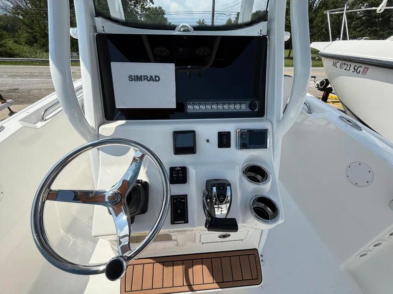 Slide: The Image of 2018 Tidewater 232 LXF boat console with steering wheel and Simrad navigation system. - 11