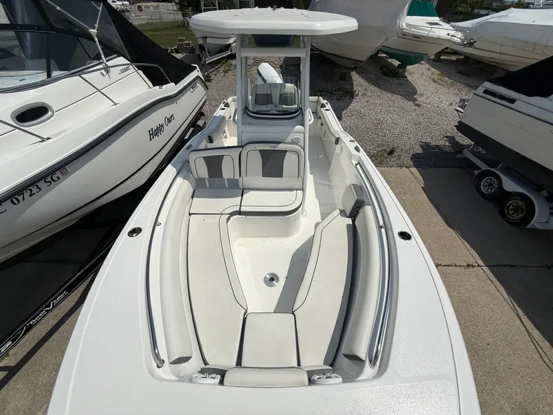 Slide: The Image of 2018 Tidewater 232 LXF boat with spacious seating and sleek design, docked among other boats. - 18