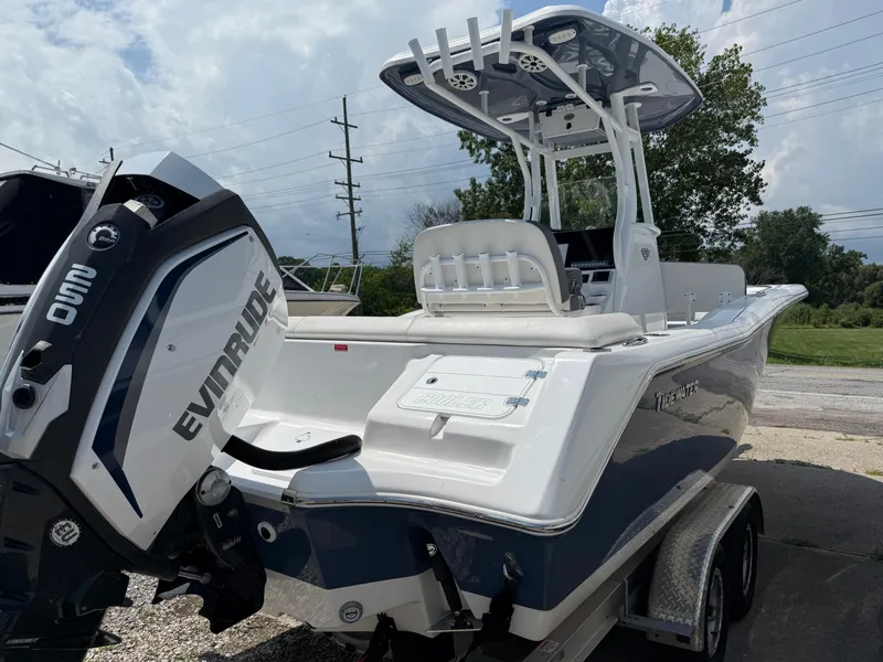Slide: The Image of 2018 Tidewater 232 LXF boat with Evinrude engine, parked on a trailer. - 4