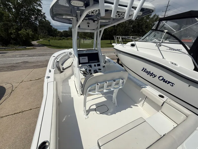 Slide: The Image of 2018 Tidewater 232 LXF boat interior with helm and seating, docked beside another boat. - 6