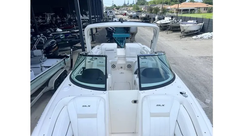 Slide: The Image of 2008 Sea Ray 270SLX boat with open deck and seating, parked in a marina. - 4