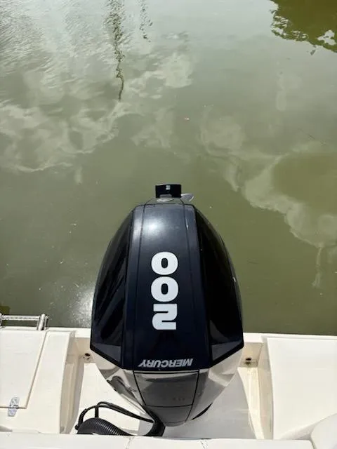 Slide: The Image of 2023 Cobia 220 Dual Console with Mercury 200 outboard engine on calm water. - 8