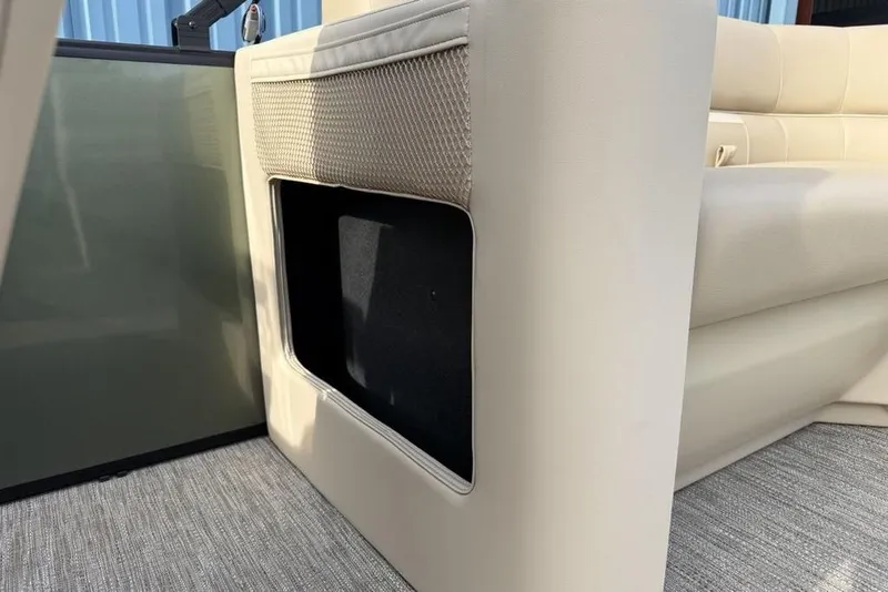Slide: The Image of Interior view of 2025 Godfrey Xperience 2286 SBX boat, featuring beige seating and storage compartment. - 23