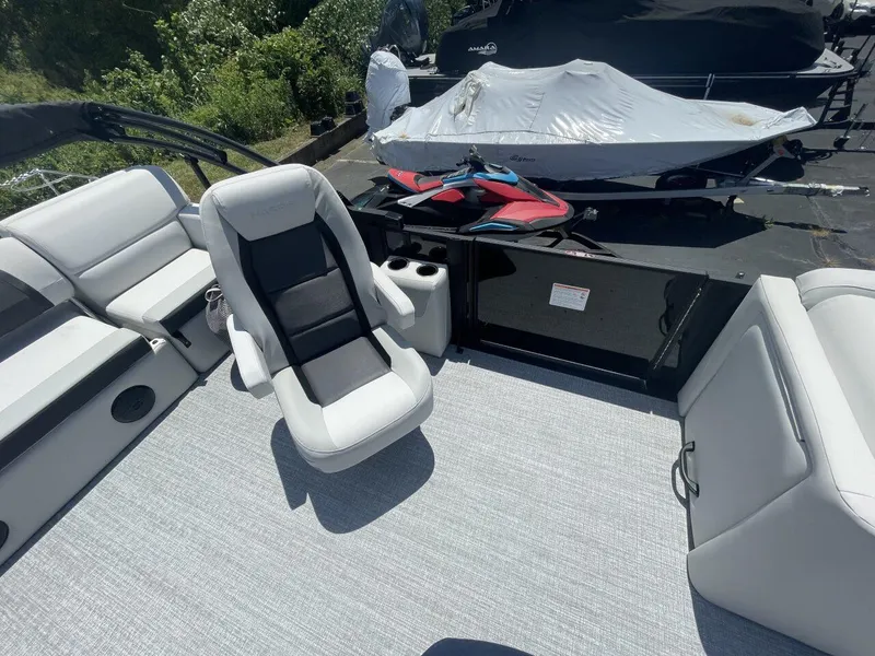 Slide: The Image of 2026 Harris Cruiser 210 boat interior with white seating and a covered jet ski nearby. - 10