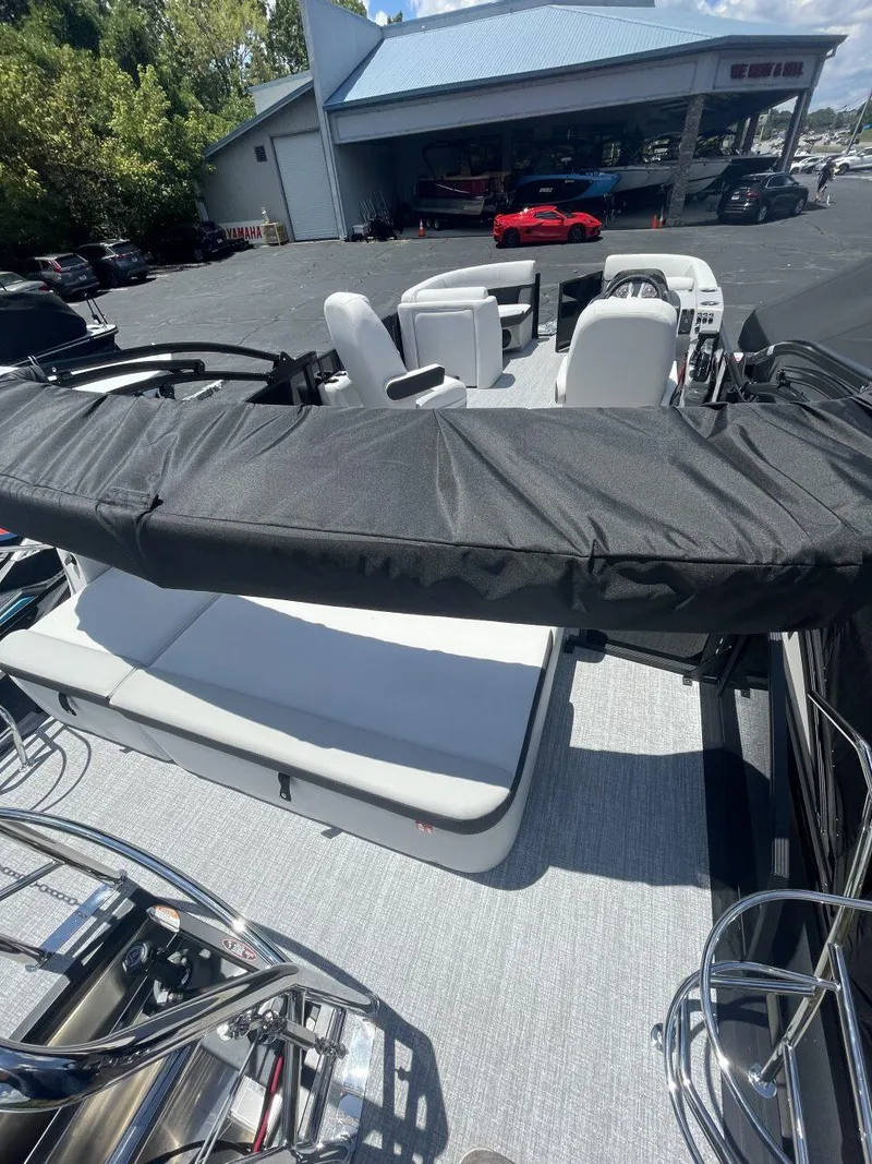 Slide: The Image of 2026 Harris Cruiser 210 boat interior with seating, parked at a dealership. - 12