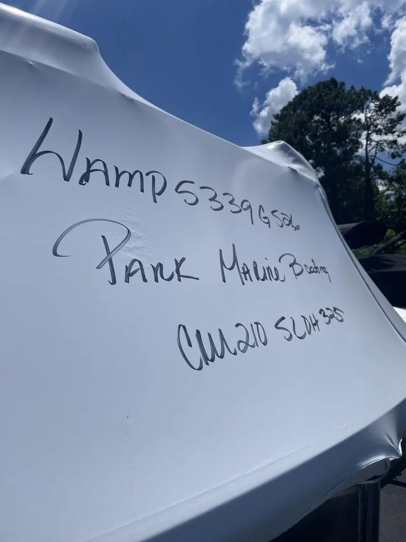 Slide: The Image of 2026 Harris Cruiser 210 boat covered, handwritten text visible, blue sky background. - 19