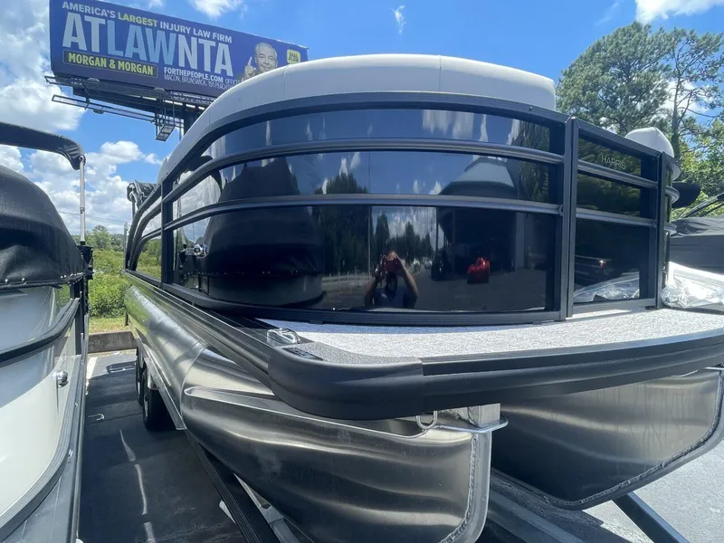 Slide: The Image of 2026 Harris Cruiser 210 pontoon boat displayed outdoors under a clear blue sky. - 2