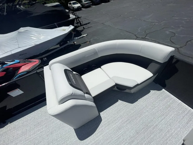 Slide: The Image of 2026 Harris Cruiser 210 boat interior with white and black seating on a sunny day. - 9