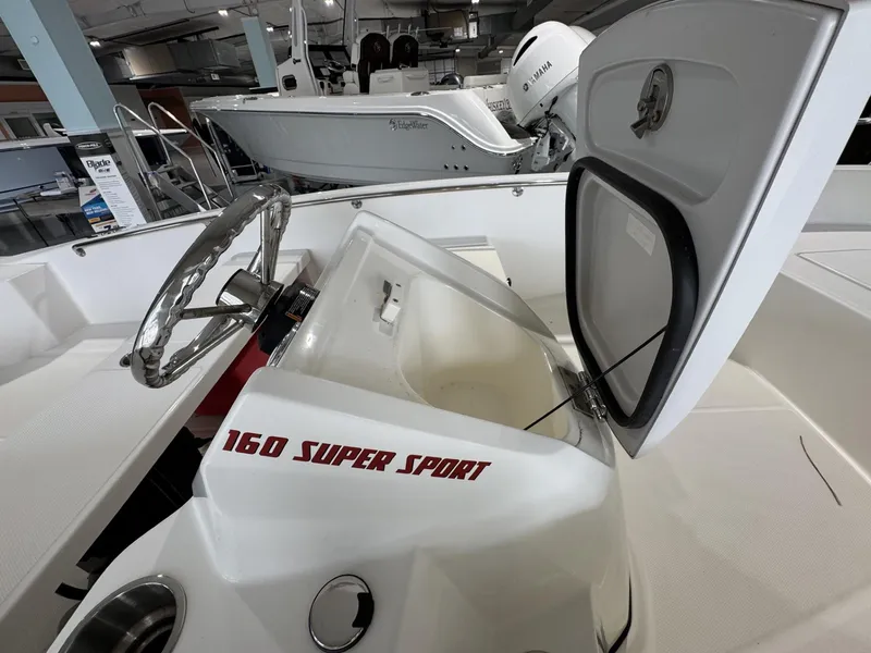 Slide: The Image of 2023 Boston Whaler 160 Super Sport boat interior with open storage compartment. - 11