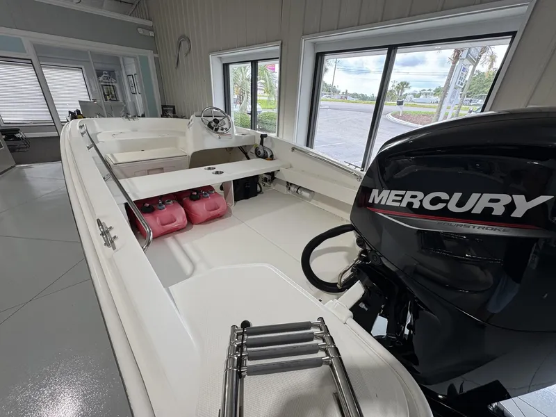 Slide: The Image of 2023 Boston Whaler 160 Super Sport boat with Mercury engine, displayed indoors. - 6