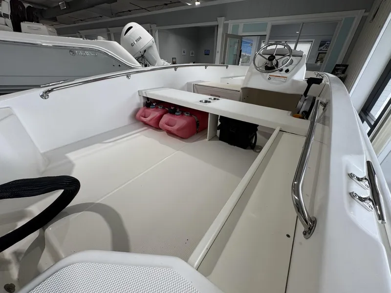 Slide: The Image of 2023 Boston Whaler 160 Super Sport interior with steering wheel and storage compartments. - 9