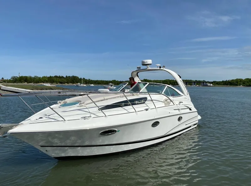 Slide: The Image of 2003 Doral 330 Elegante CR boat on calm water under clear blue sky. - 0