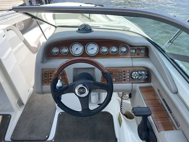 Slide: The Image of 2004 Cobalt 226 boat dashboard with wood accents and steering wheel. - 10