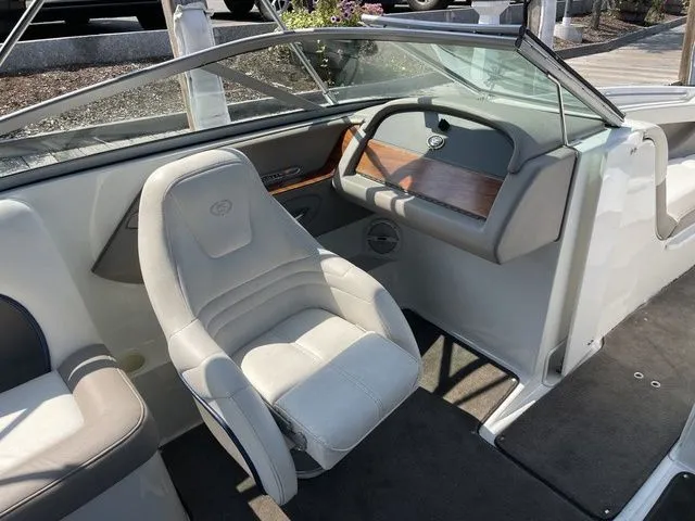 Slide: The Image of Interior of a 2004 Cobalt 226 boat featuring a white captain's chair and dashboard. - 11