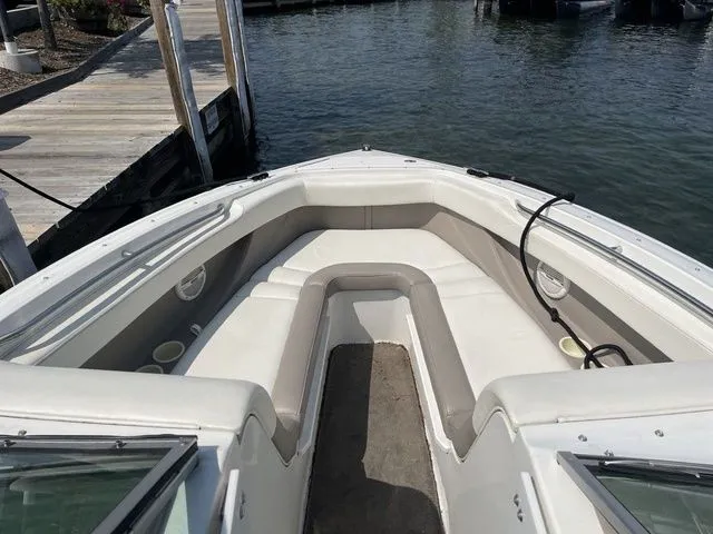 Slide: The Image of 2004 Cobalt 226 boat with white seating, docked by a wooden pier. - 16