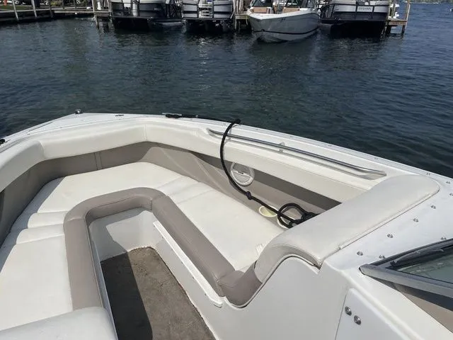 Slide: The Image of 2004 Cobalt 226 boat interior with white seating, docked by the water. - 18