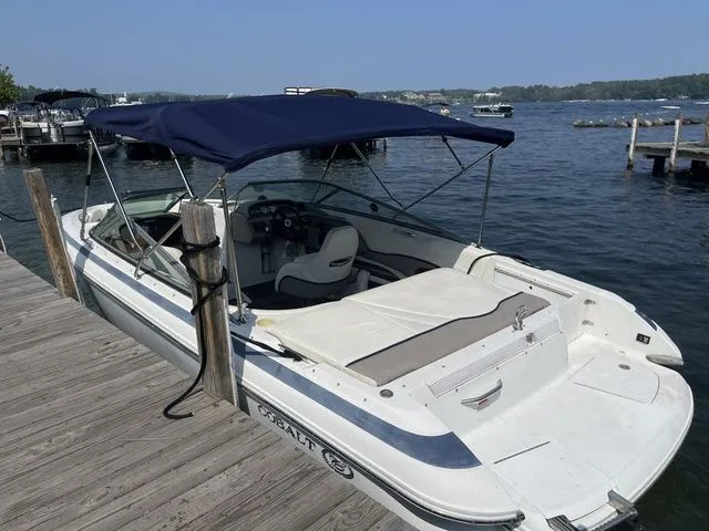 Slide: The Image of 2004 Cobalt 226 boat docked by a lake with a blue canopy. - 19