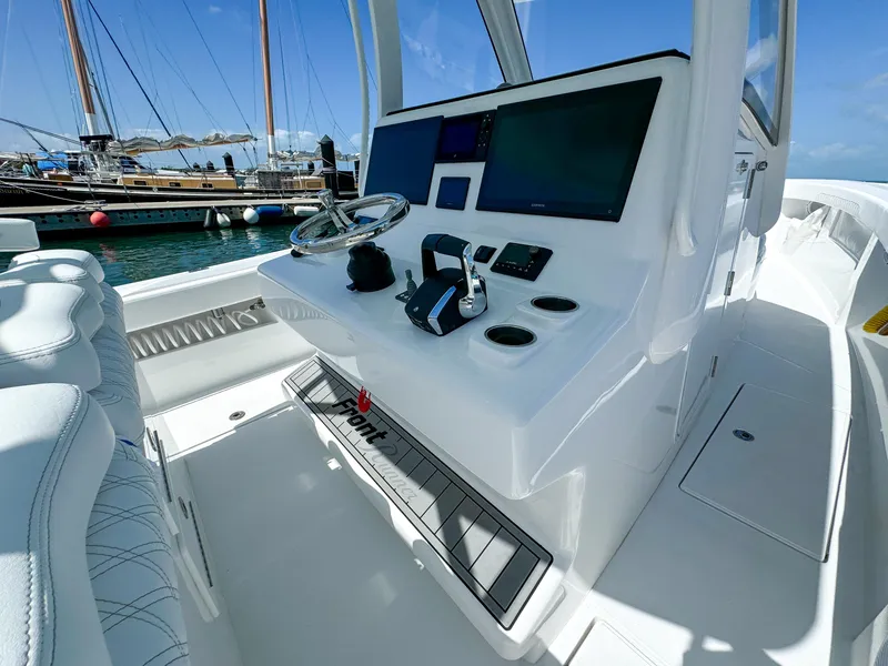 Slide: The Image of 2025 Front Runner 36 cc boat cockpit with modern controls and steering wheel, docked at marina. - 12