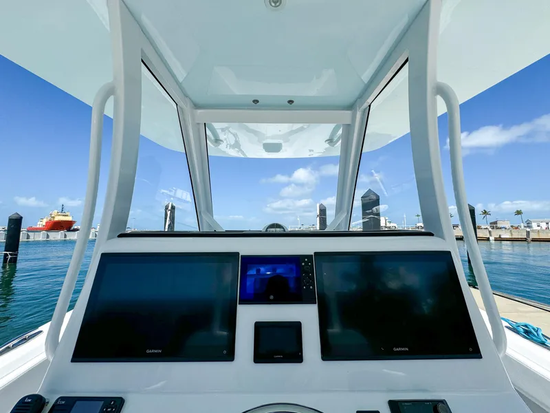 Slide: The Image of 2025 Front Runner 36 cc boat cockpit with advanced navigation screens, docked at marina. - 13