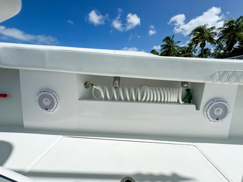 Slide: The Image of 2025 Front Runner 36 cc boat deck with speakers and coiled hose under blue sky. - 19