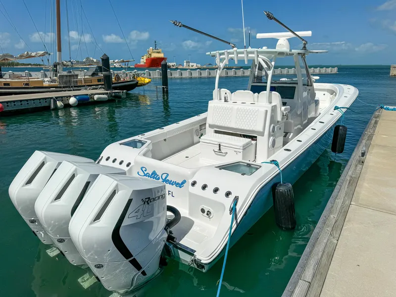 Slide: The Image of 2025 Front Runner 36 cc boat docked, featuring triple outboard engines, in a sunny marina setting. - 4