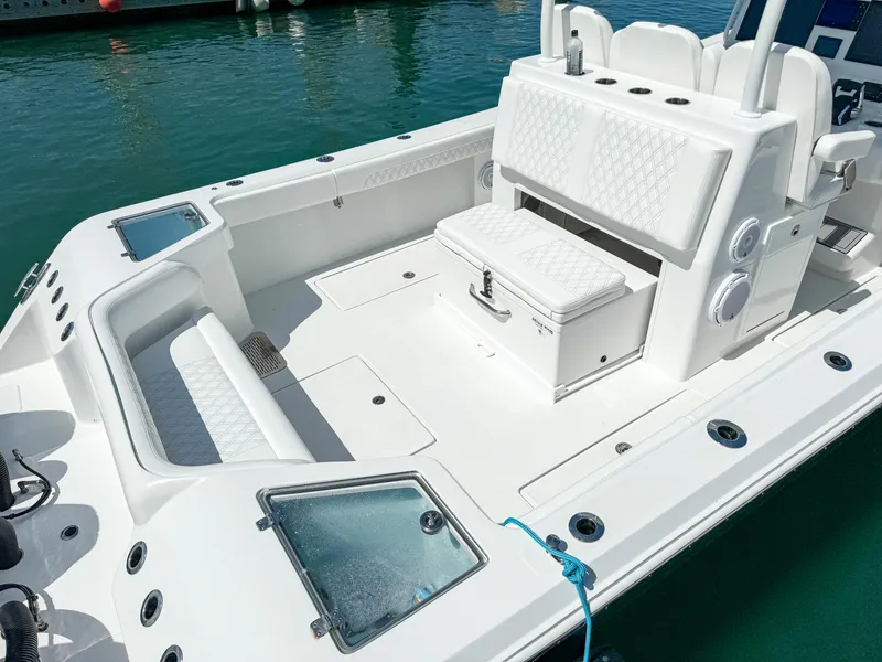 Slide: The Image of 2025 Front Runner 36 cc boat interior with white seating and storage, docked on clear water. - 6