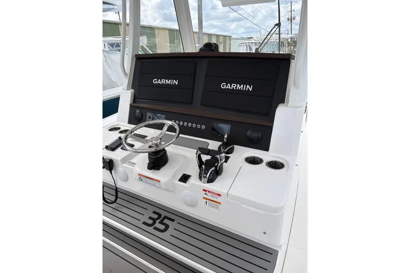 Slide: The Image of 2026 Regulator 35 boat dashboard with Garmin displays and steering wheel. - 14
