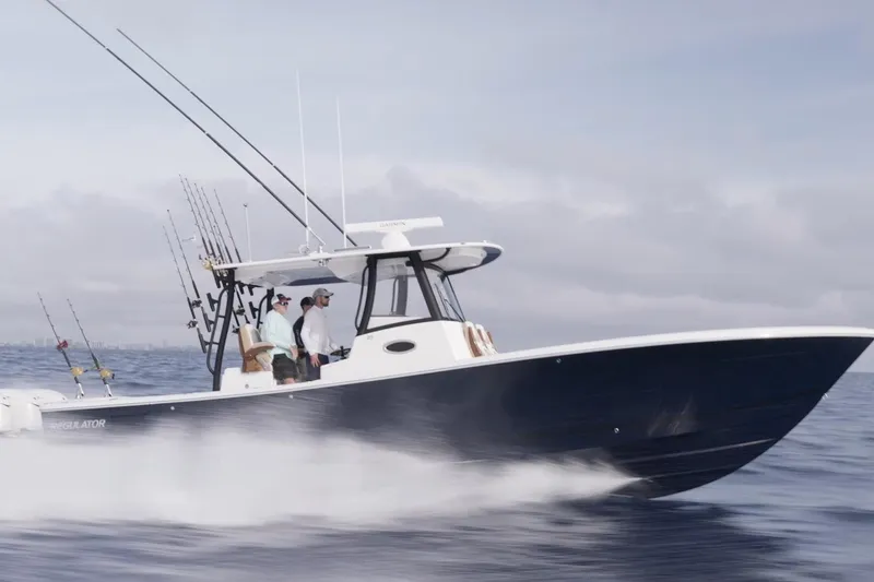 The Image of 2026 Regulator 35 boat speeding on open water with fishing rods. - 2