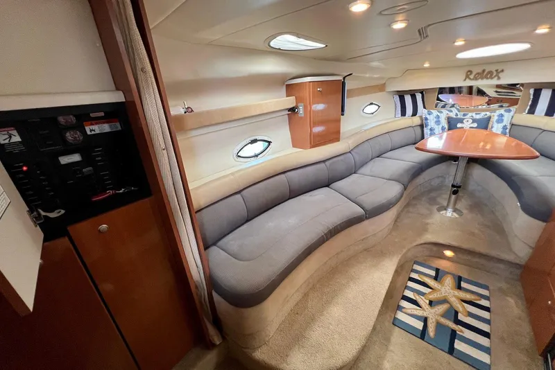 Slide: The Image of 2006 Maxum 3100 SE cabin interior with curved seating, table, and nautical decor. - 13