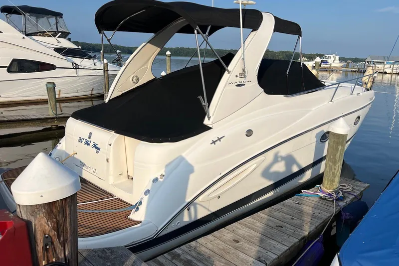Slide: The Image of 2006 Maxum 3100 SE boat docked at marina with black canopy. - 2