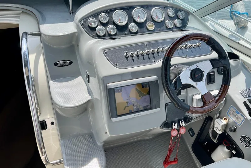 Slide: The Image of 2006 Maxum 3100 SE boat dashboard with steering wheel, gauges, and navigation system. - 6