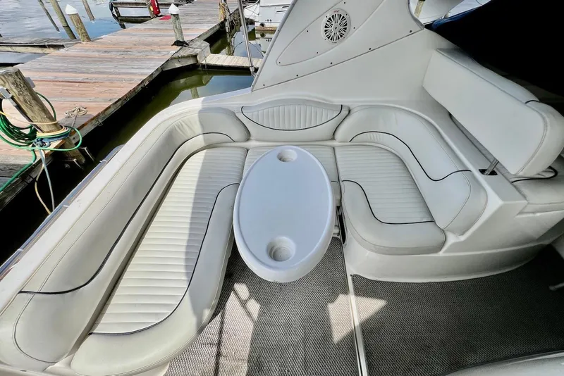 Slide: The Image of 2006 Maxum 3100 SE boat interior with white seating and oval table at dock. - 8