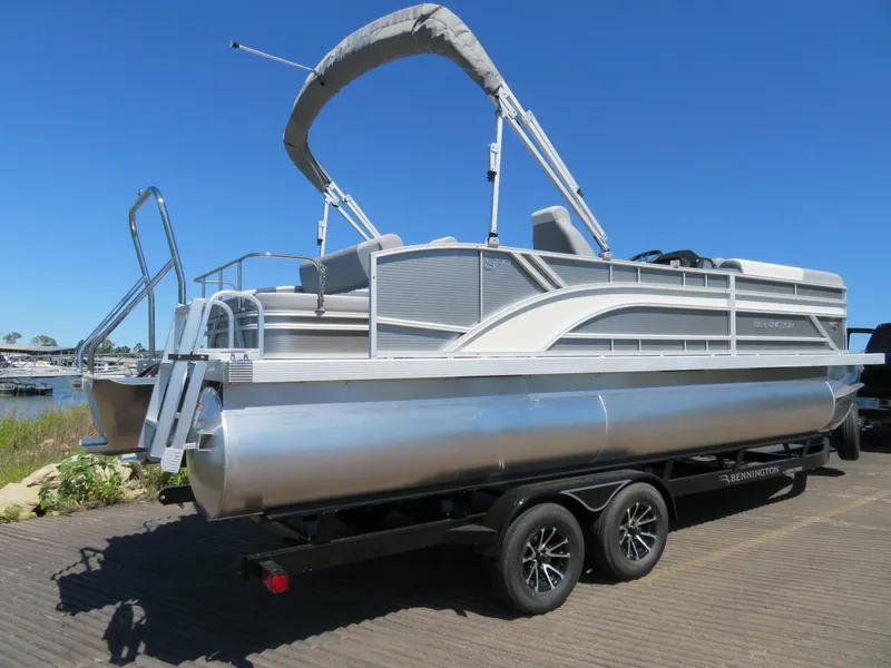 Slide: The Image of 2024 Bennington S22 SB pontoon boat on trailer under clear blue sky. - 3