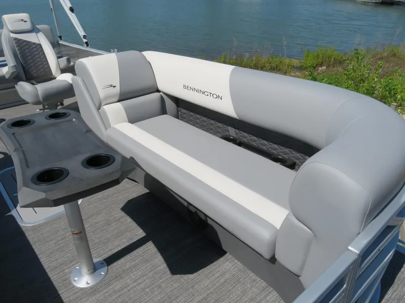 Slide: The Image of 2024 Bennington S22 SB pontoon boat interior with gray seating and cup holders. - 4