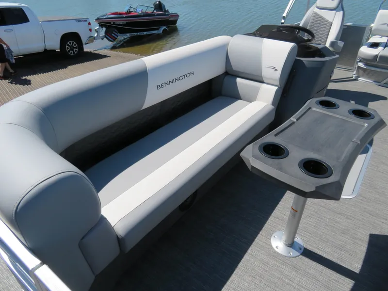 Slide: The Image of 2024 Bennington S22 SB pontoon boat interior with gray seating and cupholder table. - 5