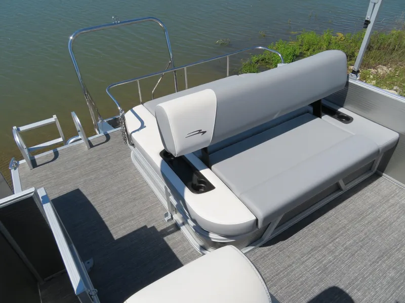 Slide: The Image of 2024 Bennington S22 SB pontoon boat with gray seating and water backdrop. - 8