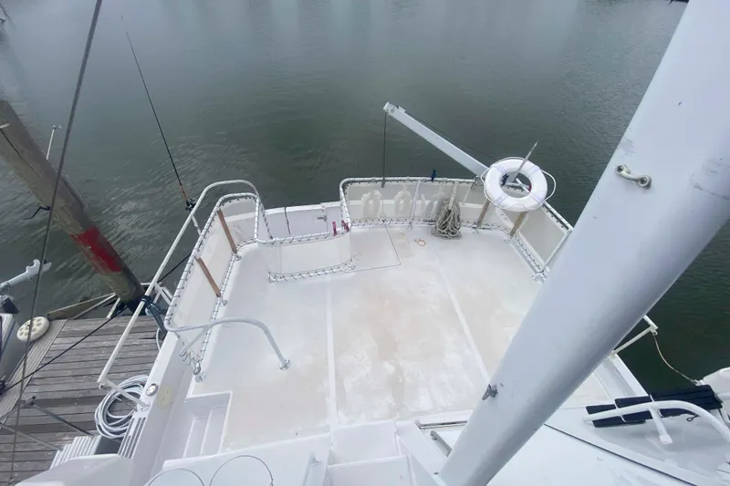 Slide: The Image of 1999 Mainship 430 Trawler deck view, featuring spacious layout and safety railings. - 16