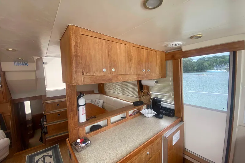 Slide: The Image of Interior of 1999 Mainship 430 Trawler with wooden cabinetry and lake view. - 25