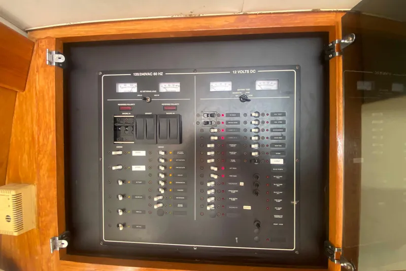 Slide: The Image of Electrical panel of a 1999 Mainship 430 Trawler, featuring AC and DC controls. - 26