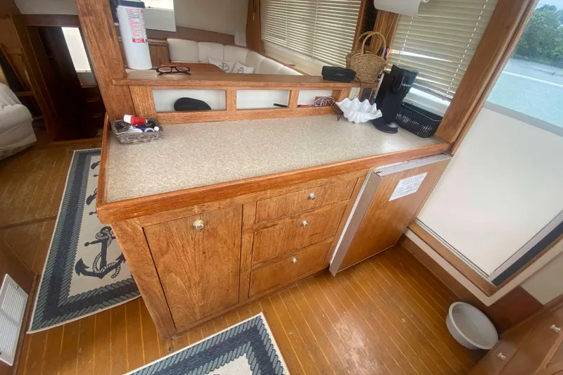Slide: The Image of 1999 Mainship 430 Trawler interior with wooden cabinetry and nautical-themed decor. - 28