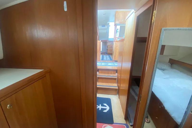 Slide: The Image of Interior of 1999 Mainship 430 Trawler with wooden cabinetry and cozy sleeping quarters. - 33