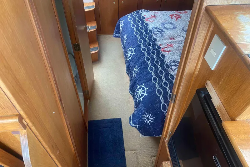 Slide: The Image of Cozy cabin interior of 1999 Mainship 430 Trawler with nautical-themed bedding. - 34