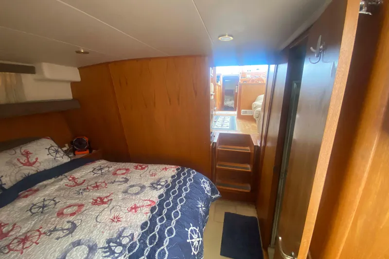 Slide: The Image of Cozy cabin interior of 1999 Mainship 430 Trawler with nautical-themed bedding. - 37