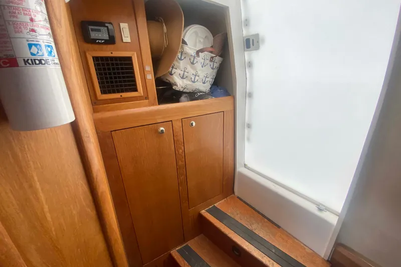 Slide: The Image of Interior of 1999 Mainship 430 Trawler with wooden cabinets and nautical decor. - 39