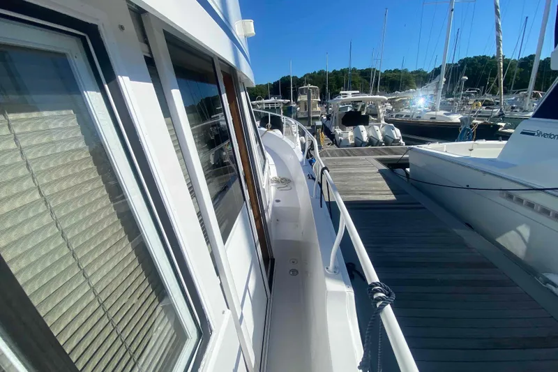 Slide: The Image of 1999 Mainship 430 Trawler docked at marina, side view with clear blue sky. - 4