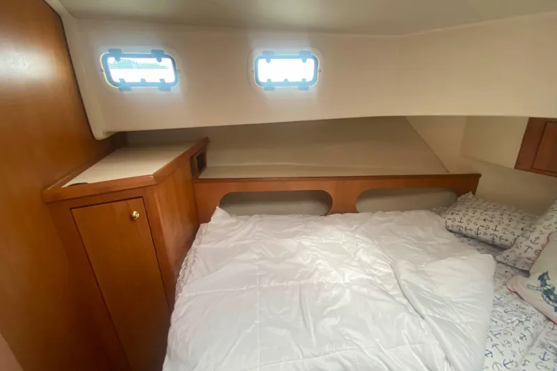 Slide: The Image of Cozy cabin interior of 1999 Mainship 430 Trawler with bed and wooden cabinetry. - 41