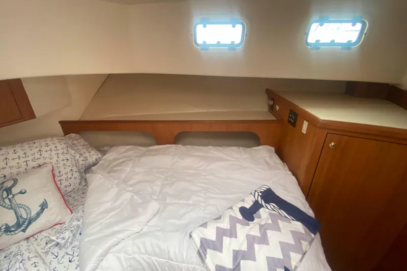 Slide: The Image of Cozy cabin interior of 1999 Mainship 430 Trawler with nautical-themed bedding. - 42