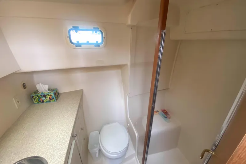 Slide: The Image of Bathroom interior of 1999 Mainship 430 Trawler with shower, toilet, and countertop. - 43