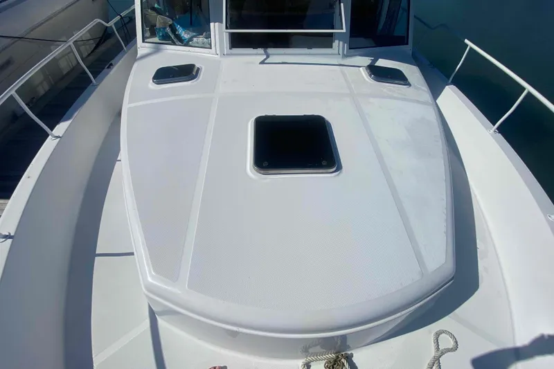 Slide: The Image of 1999 Mainship 430 Trawler deck with hatch, railing, and docked view. - 6