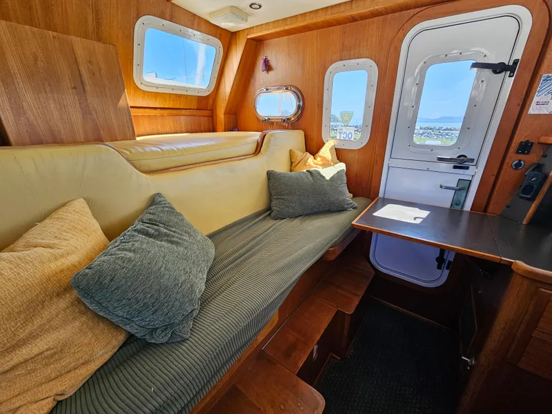 Slide: The Image of Interior of 2002 Nordhavn Trawler with cozy seating and wooden accents. - 17